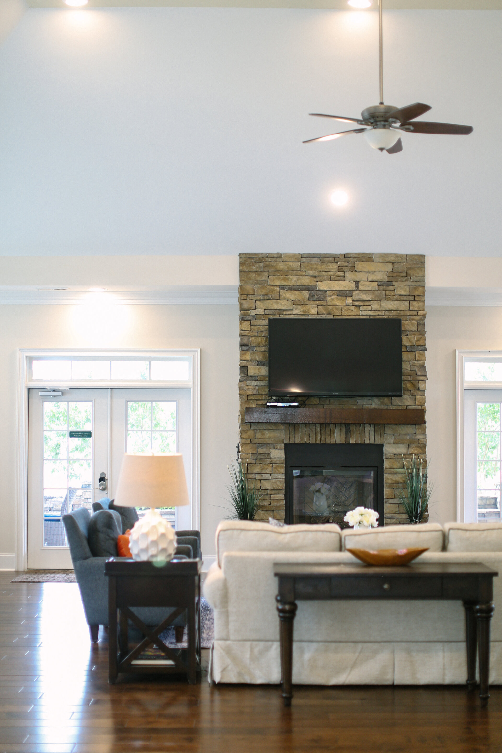 a living room with a stone fireplace and a tv above it