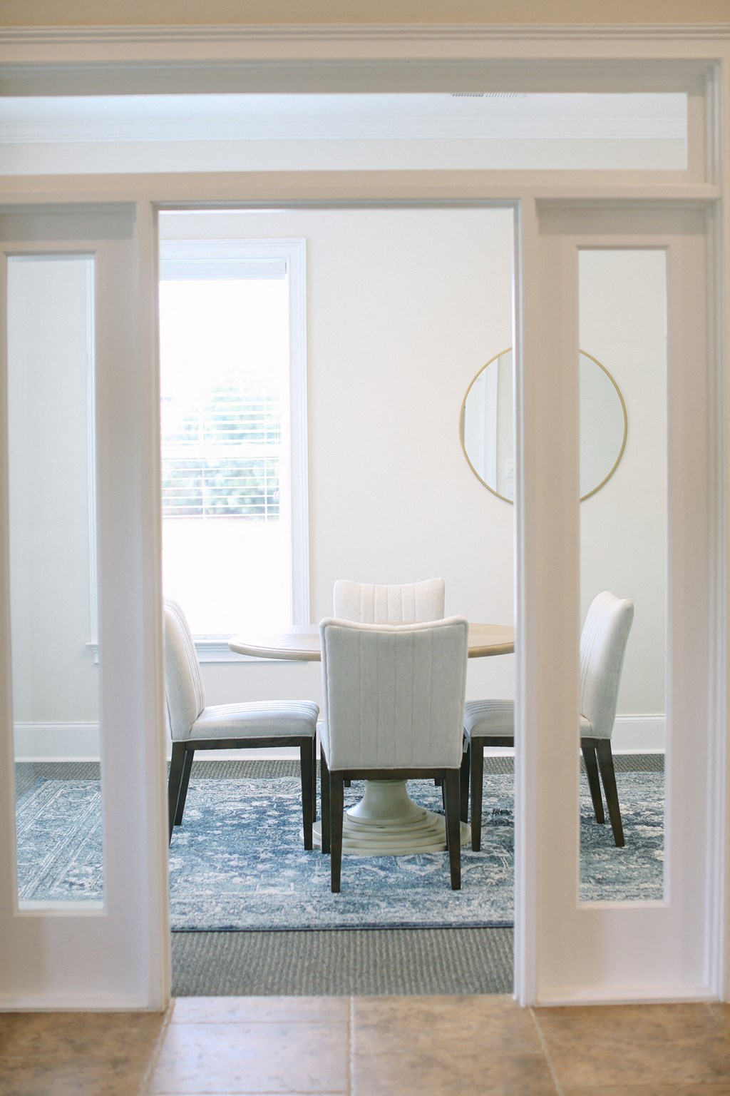 a dining room with a white table and chairs and a blue rug