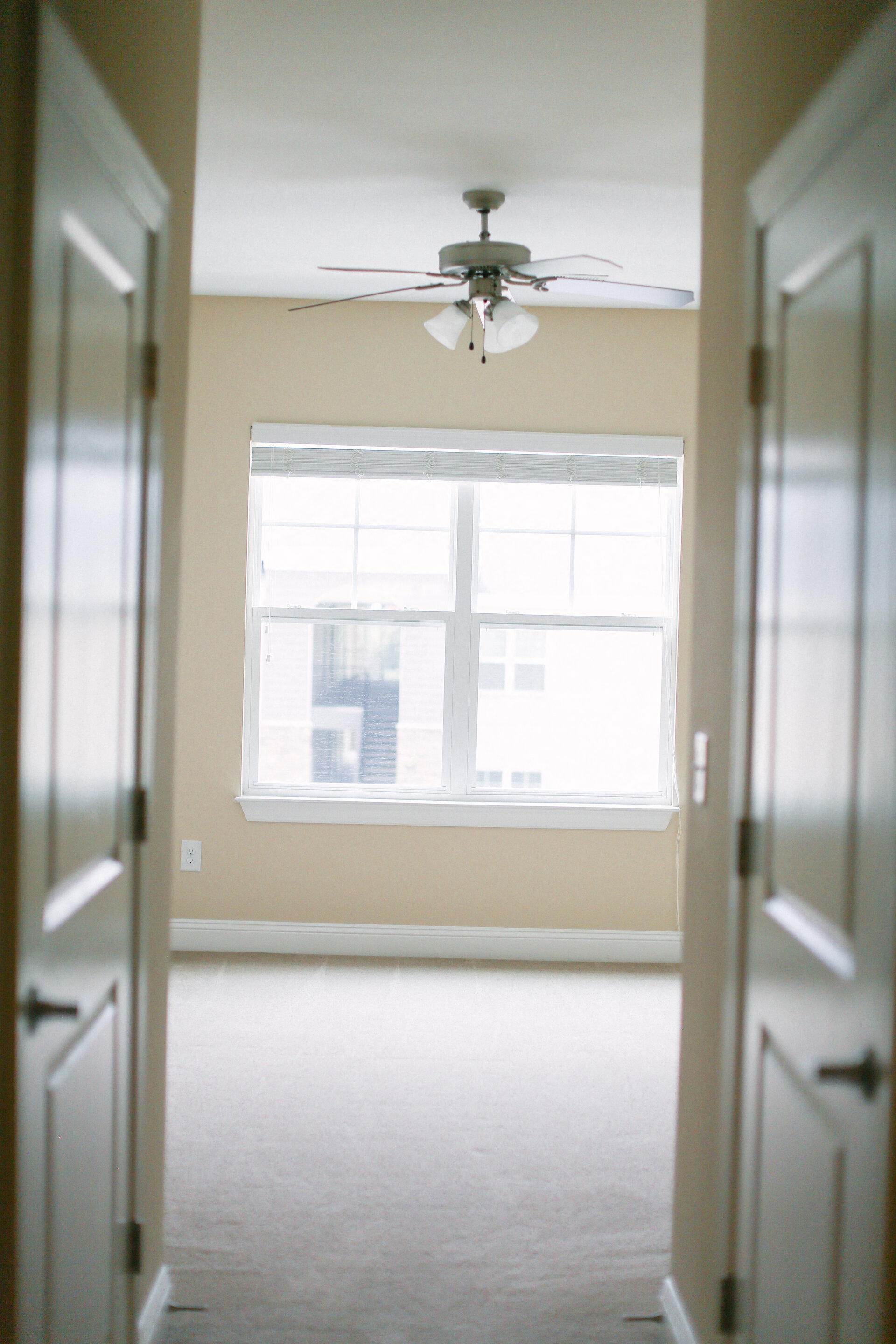 an empty room with a ceiling fan and a window