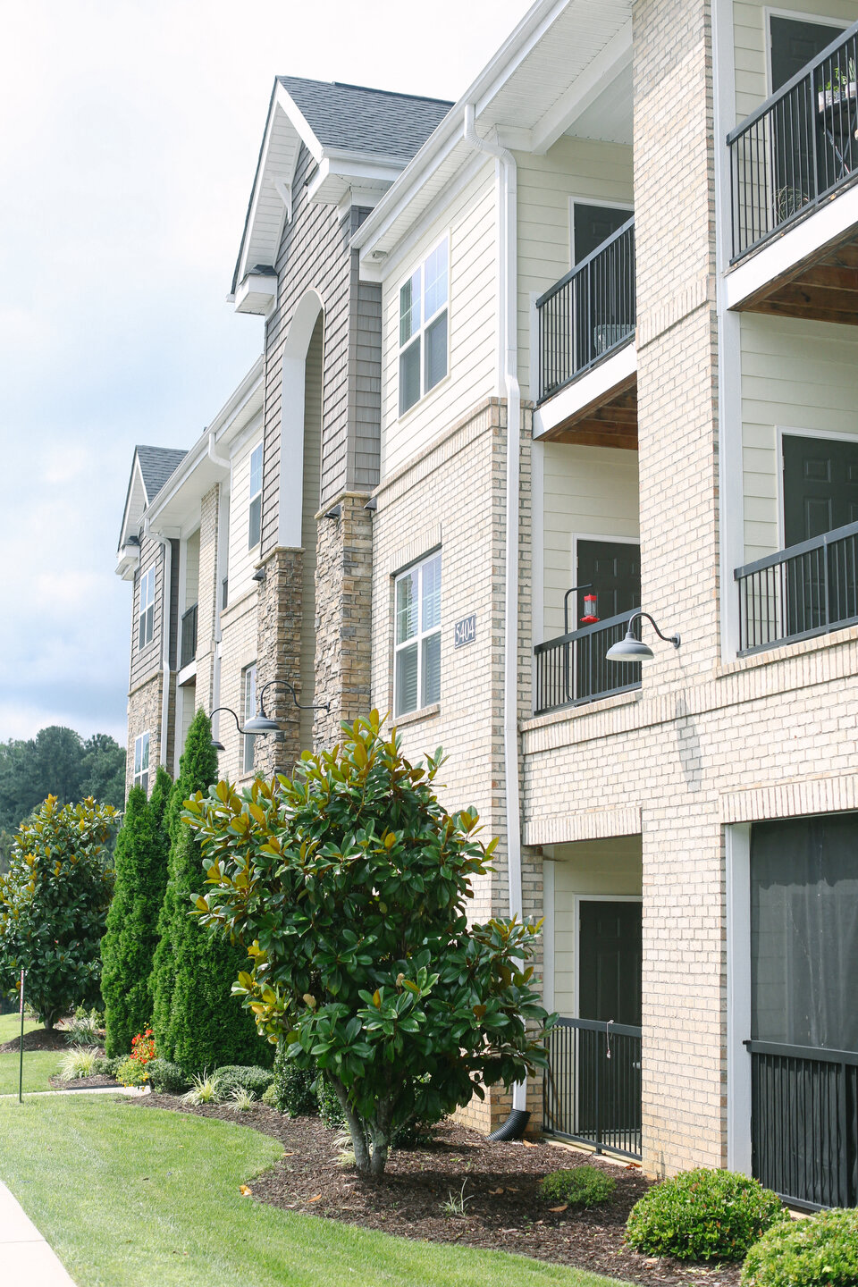 an apartment building with a tree in front of it