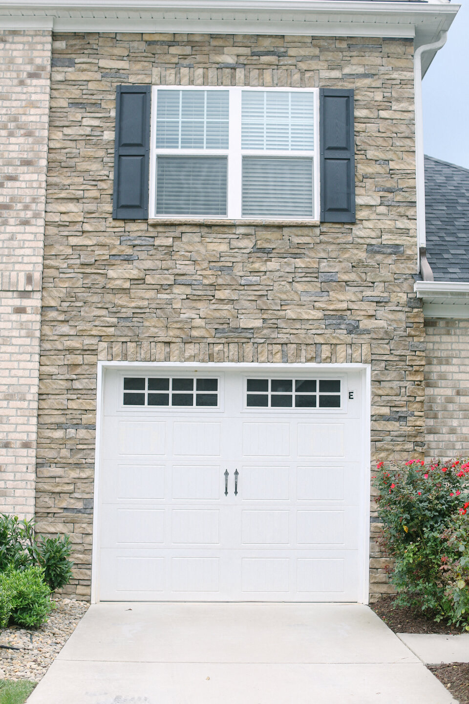 the exterior of a house with a white garage door