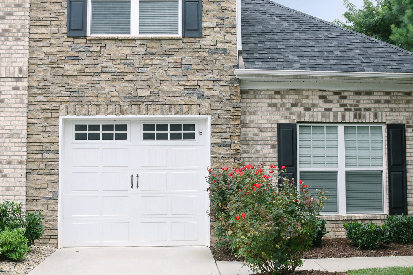 a white house with a white garage door in front of it