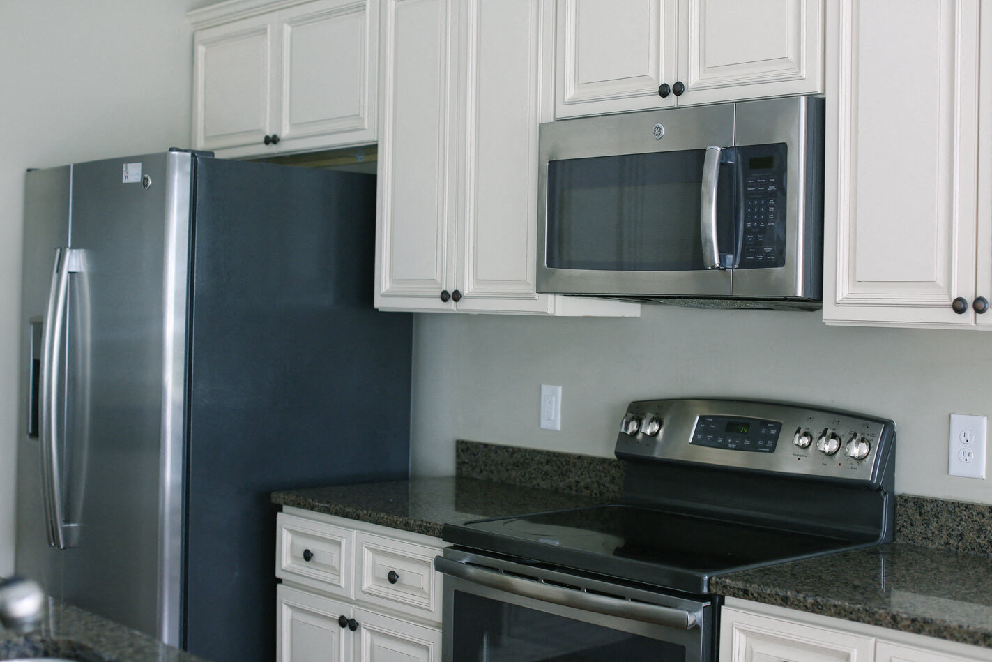 a kitchen with stainless steel appliances and white cabinets
