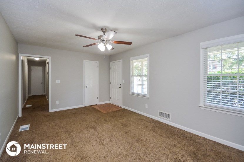 the living room of an empty house with a ceiling fan