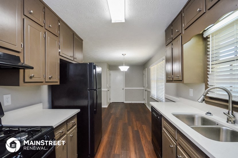 the kitchen of an apartment with a black refrigerator and a sink