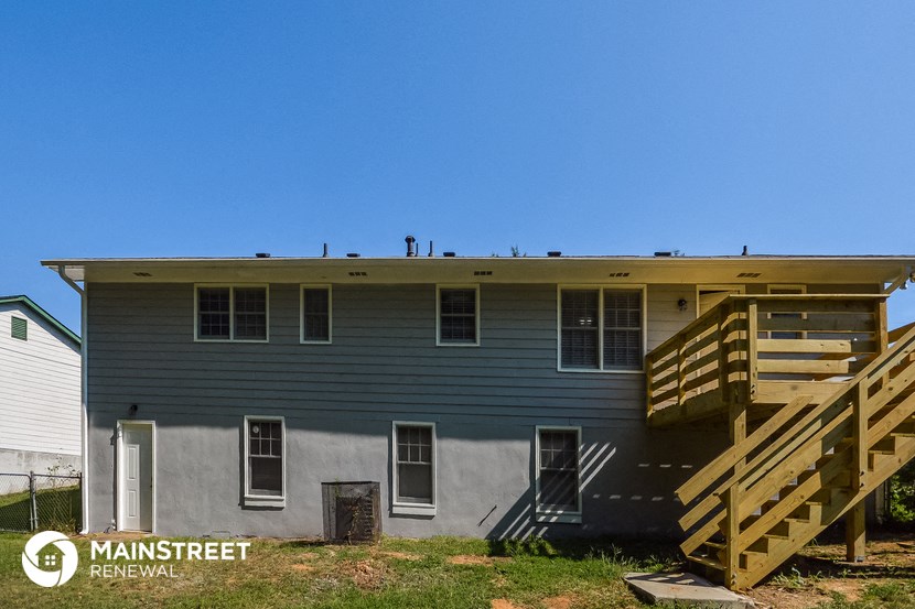 a blue house with stairs and a porch and a blue sky