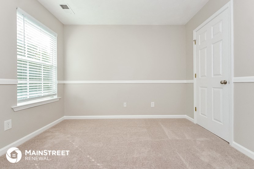 the upstairs bedroom has a carpeted floor and a white door