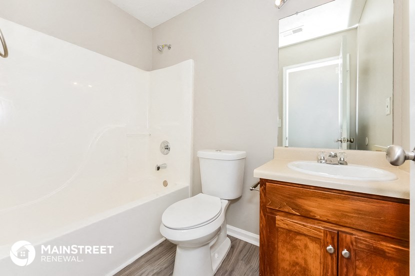 a bathroom with a toilet sink and shower and a mirror