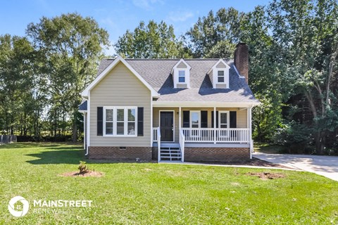 a white house with a lawn and trees