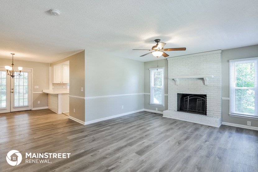 a living room with a fireplace and a ceiling fan