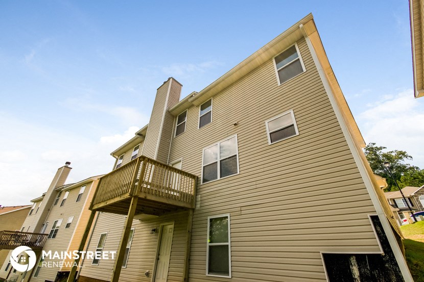 the outside of a house with a balcony and a blue sky