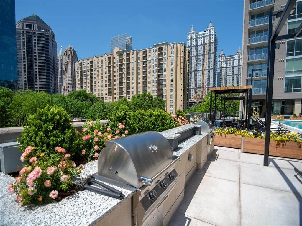 a barbecue grill on a patio in a city with tall buildings