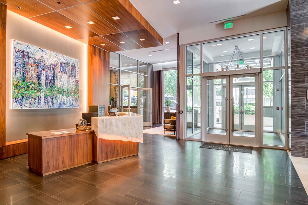 a lobby with a reception desk and glass doors