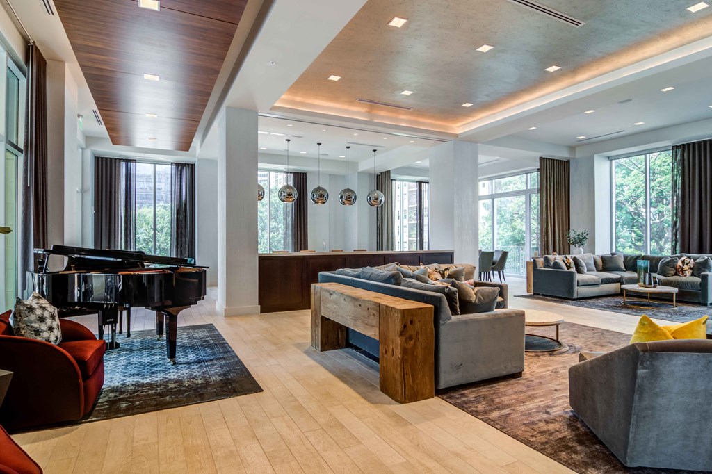 a living room with couches and a piano