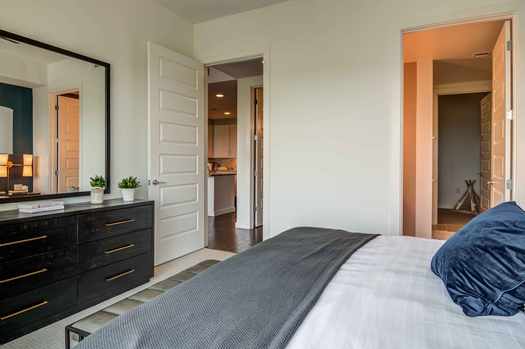 a bedroom with a bed and a dresser and a mirror