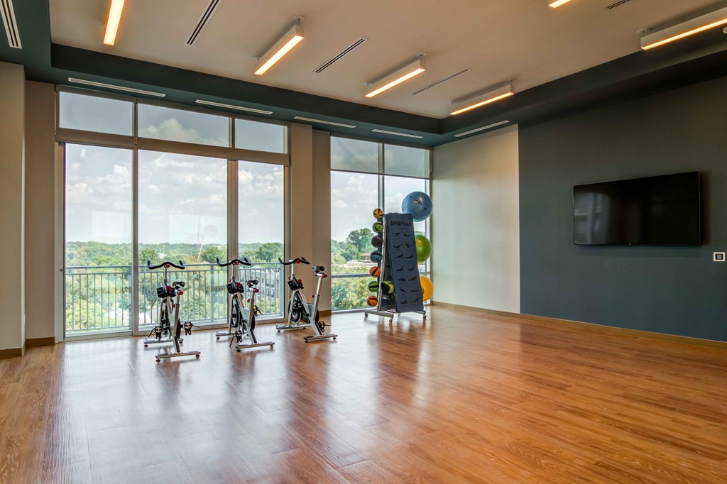a workout room with weights and a window view of the city