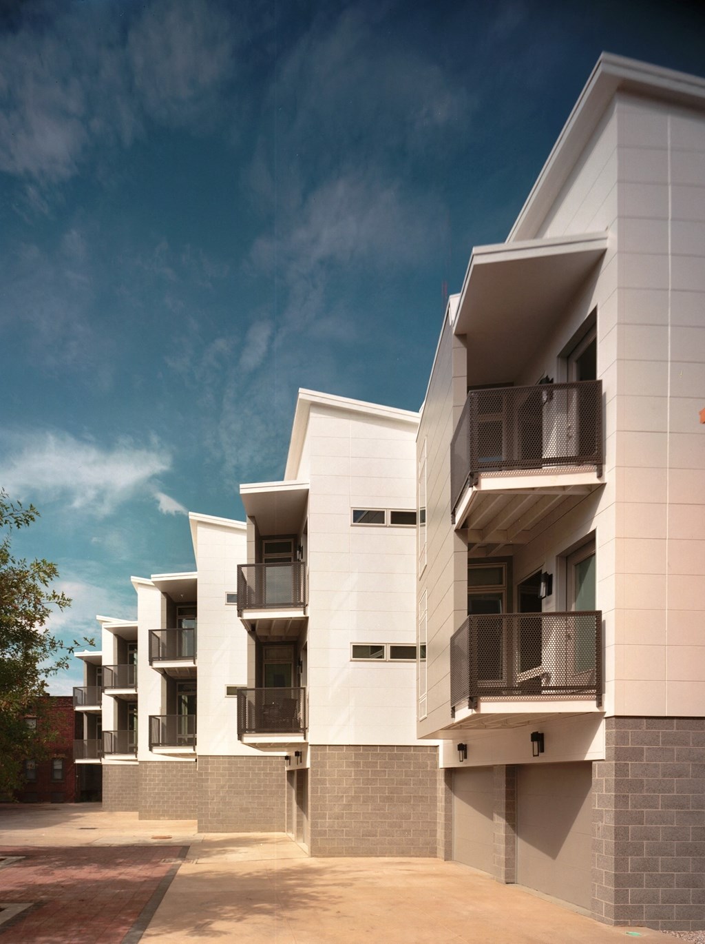 a rendering of a white apartment building with balconies