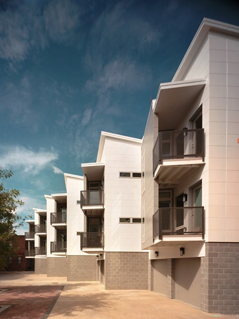 a rendering of a white apartment building with balconies