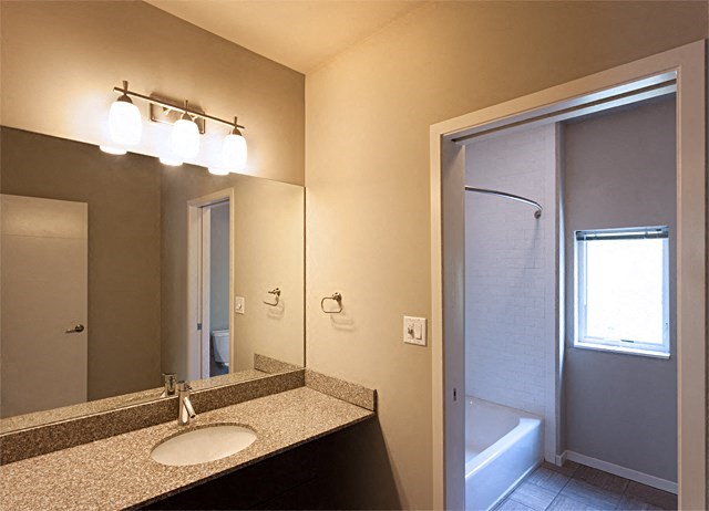 a bathroom with a sink and a mirror and a shower