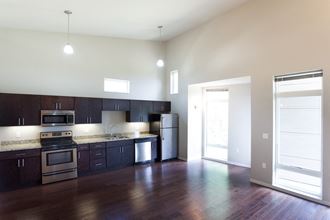 an empty kitchen with dark wood cabinets and stainless steel appliances