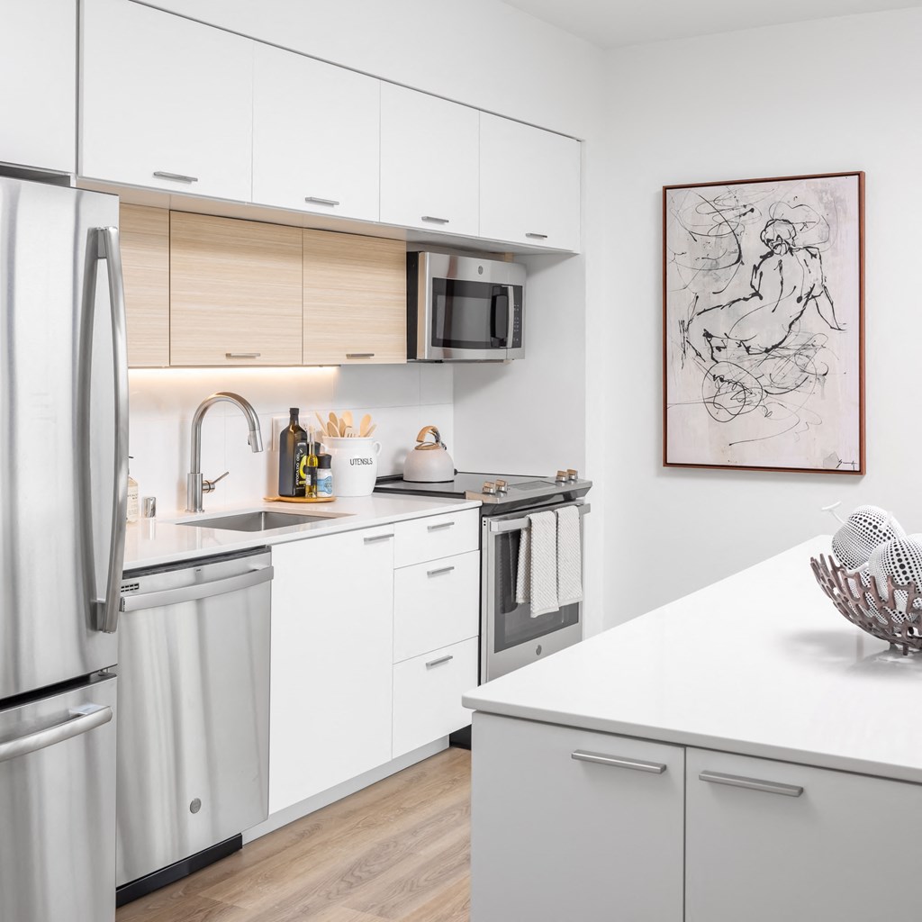Kitchen with stainless steel appliances, granite countertops and island with storage at Platform