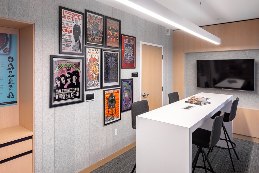a conference room with a table and chairs and posters on the wall