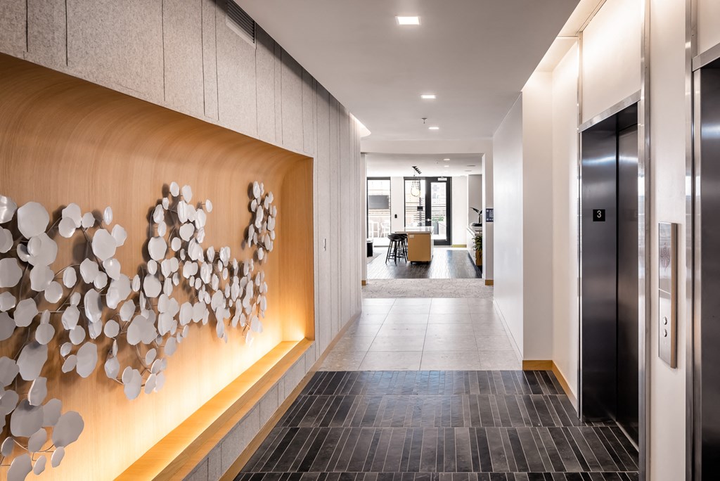 a hallway with a wood wall with shells on it and a door