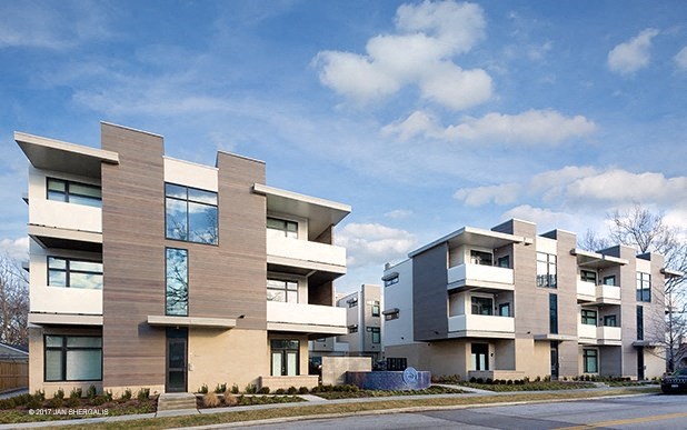 a row of modern apartment buildings on the side of a street