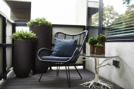 a chair and a table on a balcony with potted plants