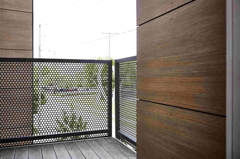 a balcony with a wood and metal fence and a wooden floor