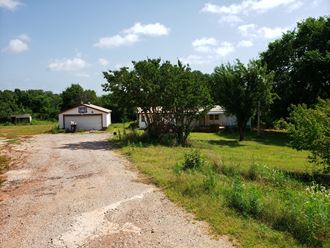 a house on the side of a dirt road
