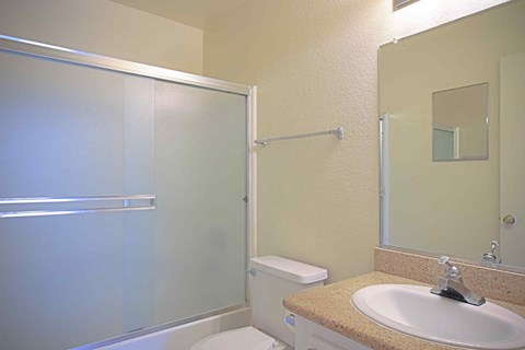 A bathroom with a sink, toilet, and shower.