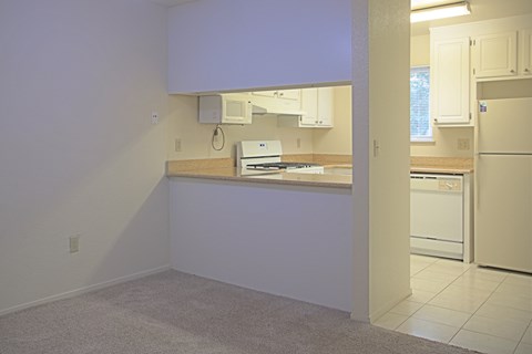 A kitchen with white appliances and cabinets.