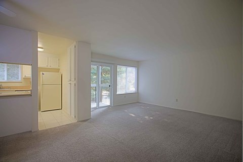A large empty room with a door leading to a balcony.