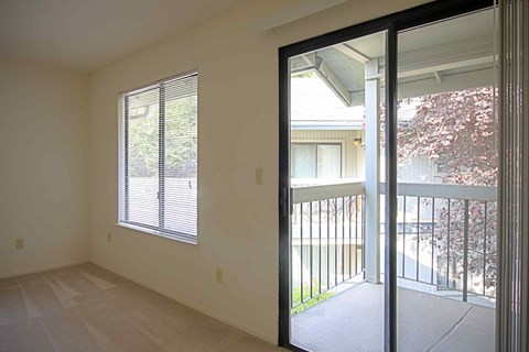 A room with a sliding glass door leading to a balcony.