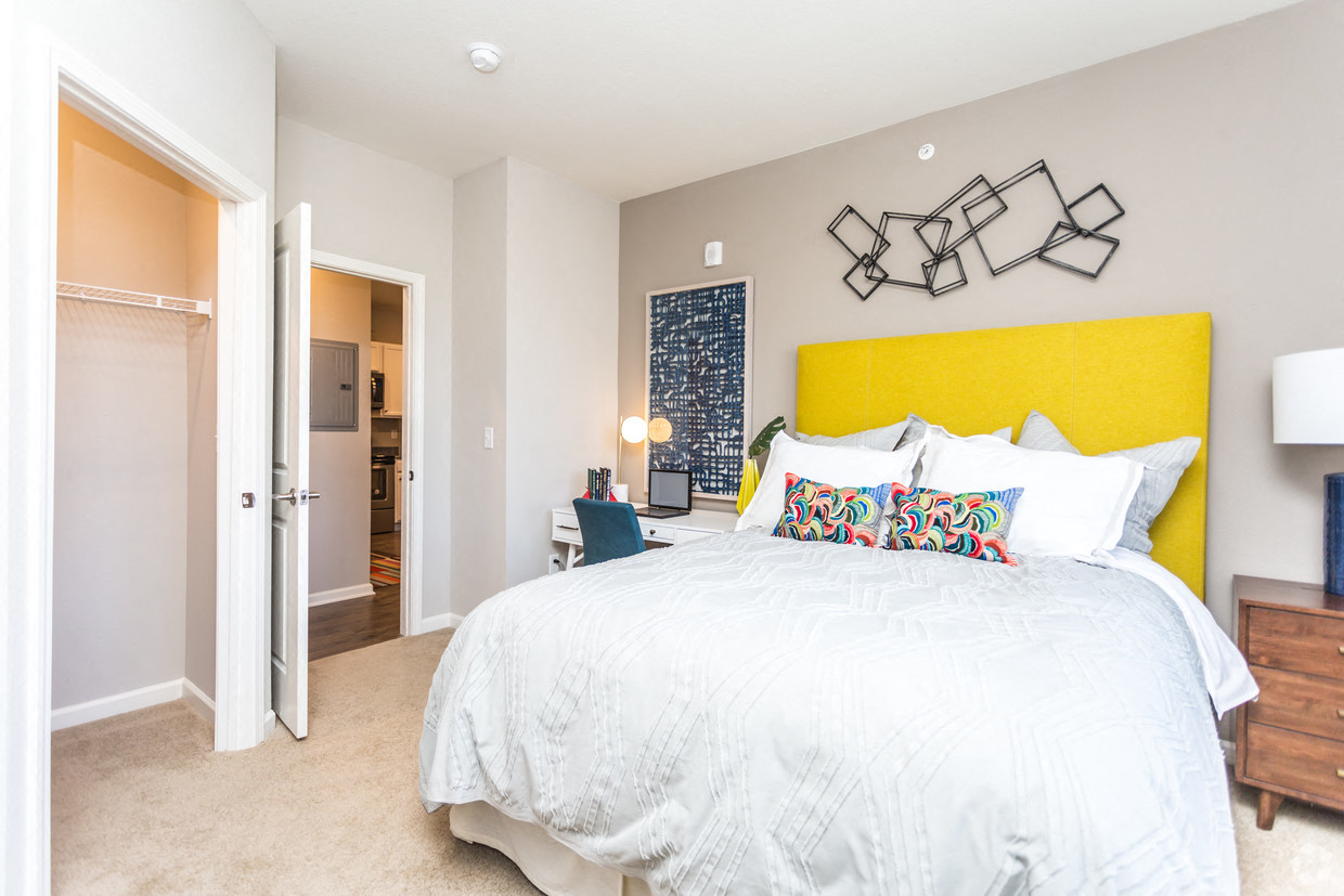 a bedroom with a yellow headboard and a white bed