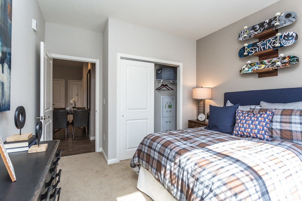 a bedroom with a bed and a view of a living room and a dining room