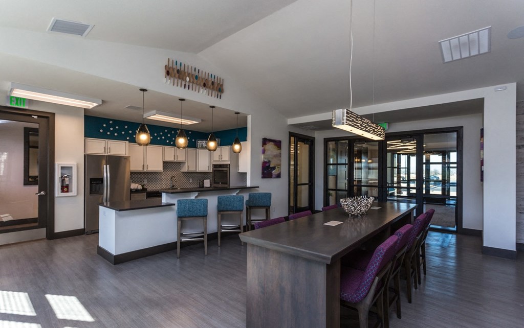 a kitchen and dining area with a bar and chairs in a building