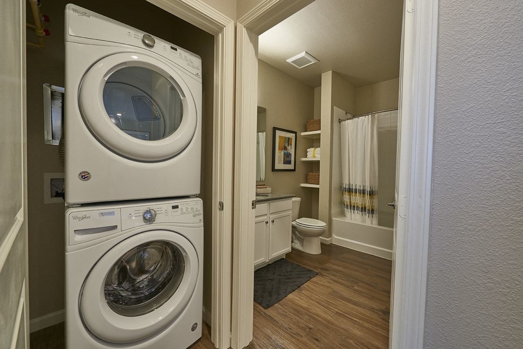 a washer and dryer in a bathroom next to a toilet