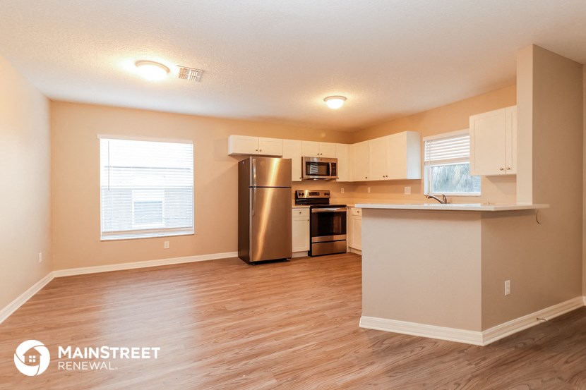 an empty kitchen with a stainless steel refrigerator and