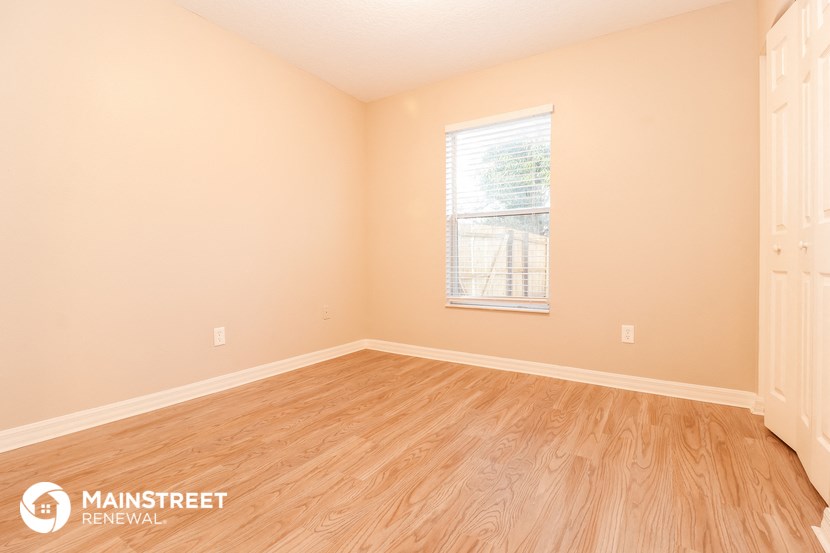 the living room of a home with wood floors and a window