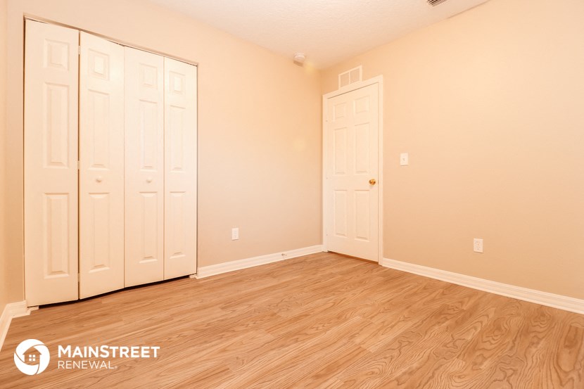 a bedroom with two closets and a wooden floor