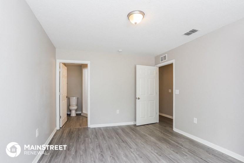 the living room of an apartment with a toilet and a door to the bathroom