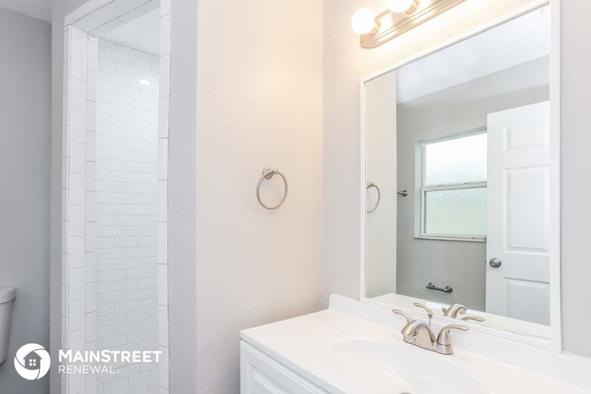 a white bathroom with a sink and a mirror