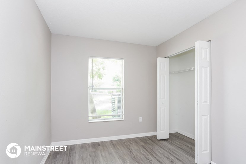 a bedroom with a window and a closet