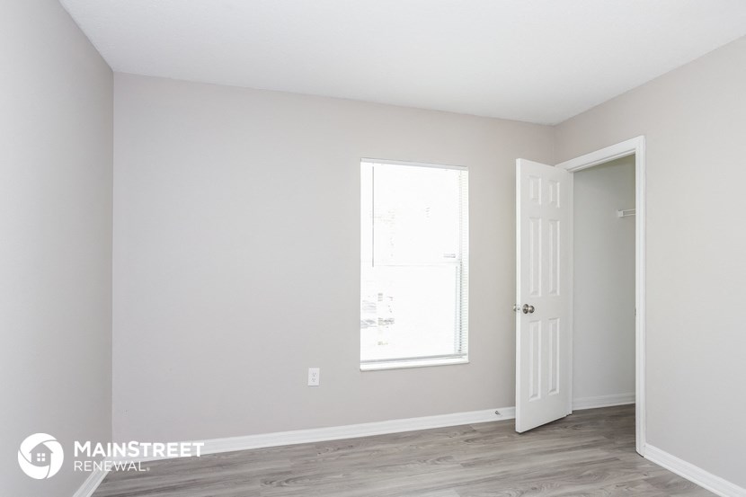the living room of an apartment with a door and a window