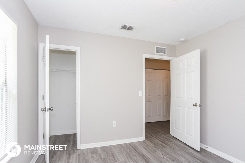 the living room and entrance to a bedroom with a door to the closet