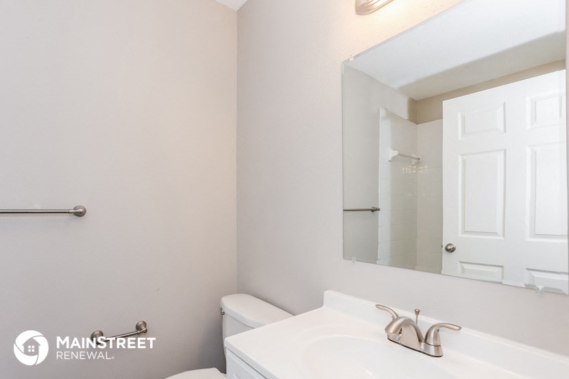 a white bathroom with a sink and a mirror