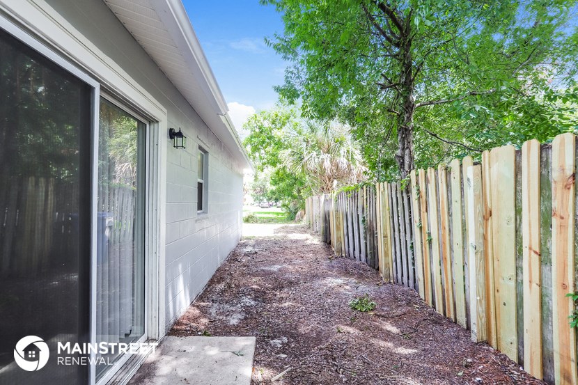 a house with a fence and a path next to it