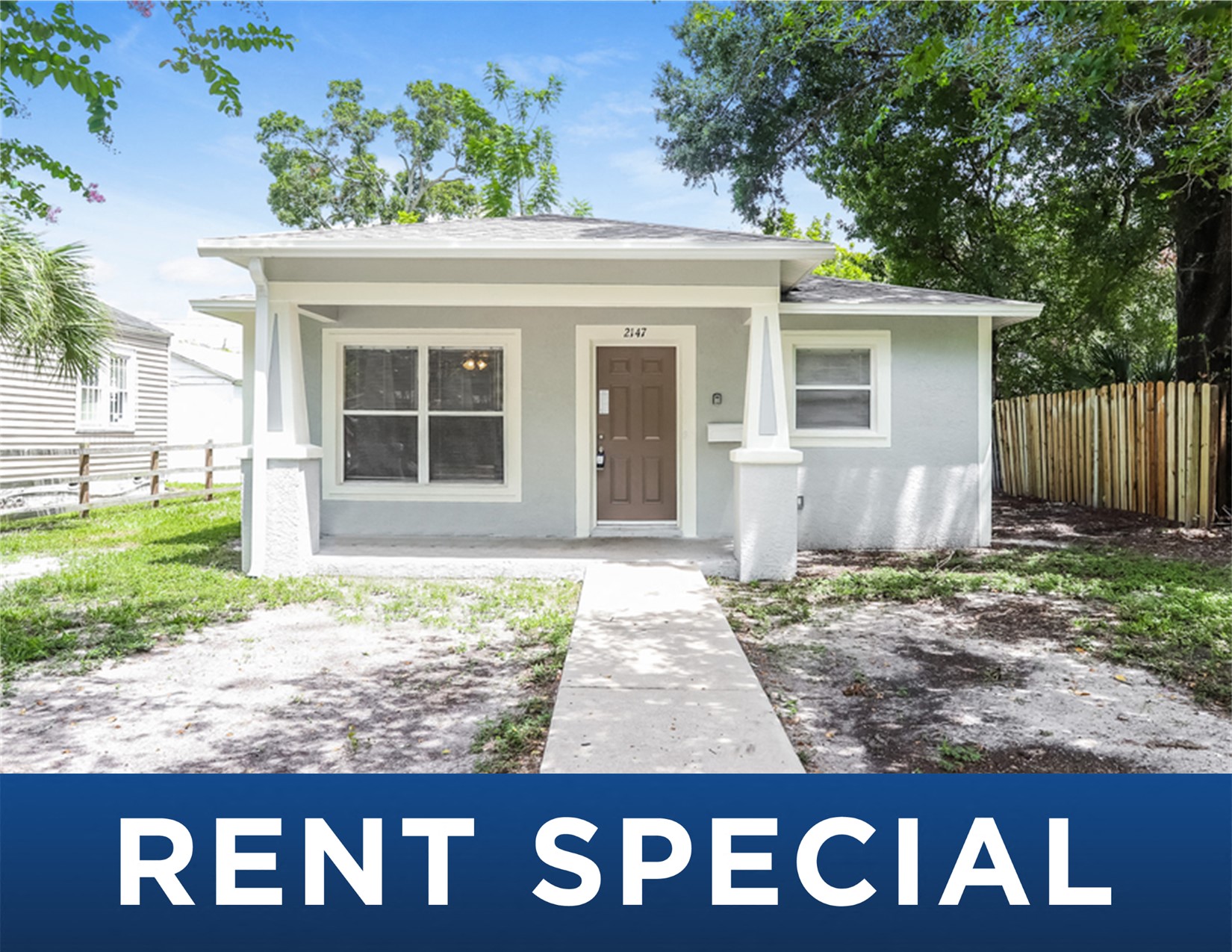 a small gray house with a front yard and the words rent special
